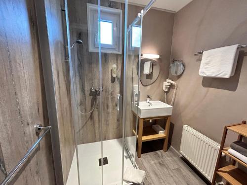 ein Bad mit einer Dusche und einem Waschbecken in der Unterkunft Hôtel de charme & SPA Le Grand Large in La Bernerie-en-Retz