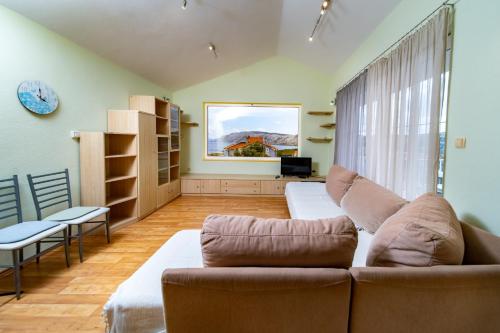 a living room with a couch and a window at Apartments Stare Brajde in Lopar
