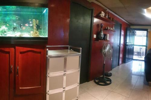 Billgren House في Imus: غرفة بها حوض سمك ومروحة أرضية