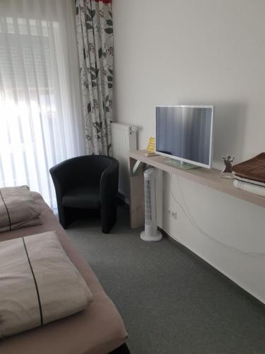 a room with two beds and a tv and a chair at Maje Am alten Binnenhafen in Emden