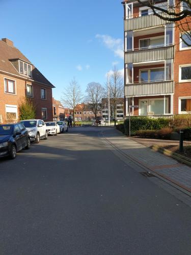 an empty street with cars parked in front of a building at Maje Am alten Binnenhafen in Emden