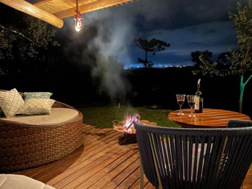 a deck with a fire pit and a table with wine glasses at Peaceandrestvillage in Colombo