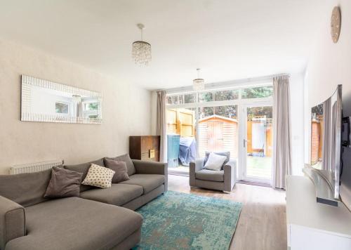 a living room with a couch and a tv at North London Suburbs in Barnet