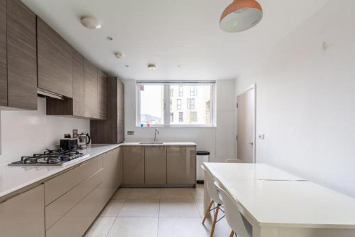 a kitchen with white cabinets and a white counter top at North London Suburbs in Barnet