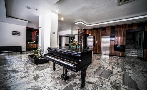 a black piano in a room with a marble floor at Hotel Inglaterra in Tampico