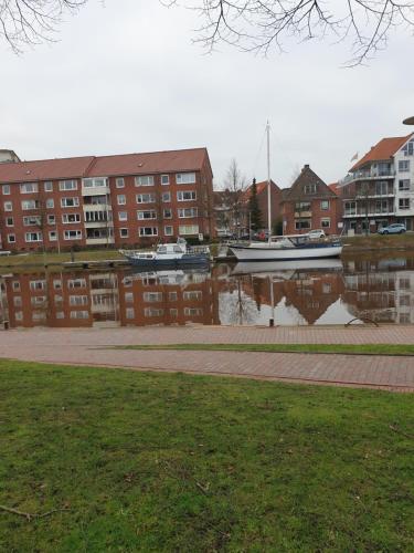 a body of water with boats in front of buildings at Maje Am alten Binnenhafen in Emden