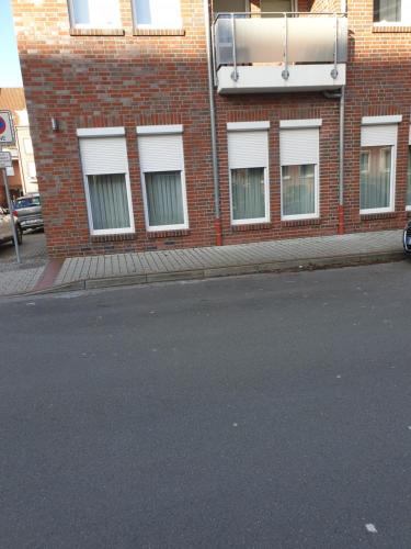 an empty street in front of a brick building at Maje Am alten Binnenhafen in Emden
