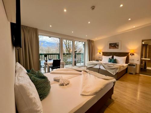 a bedroom with two beds and a large window at Gasthof Badl - Bed & Breakfast in Hall in Tirol