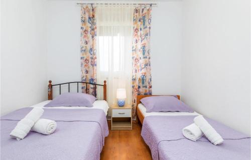 a bedroom with two beds and a window at Amazing Apartment In Peroj With 2 Bedrooms And Wifi in Peroj