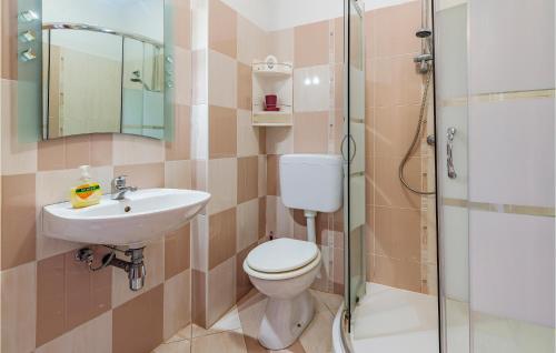 a bathroom with a toilet and a sink and a shower at Amazing Apartment In Peroj With 2 Bedrooms And Wifi in Peroj