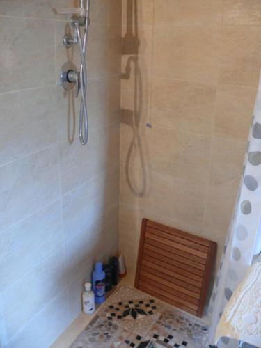 a shower with a wooden seat in a bathroom at Borgo Medievale Squillace in Squillace