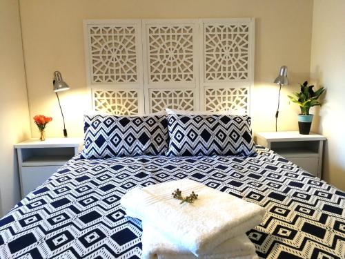 a bedroom with a large bed with a black and white at Cottage in Voëlklip between mountain and sea in Hermanus