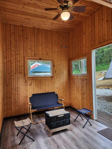 a living room with a ceiling fan and a stove at The Mountain Camp at Mesilau, Kundasang by PrimaStay in Ranau