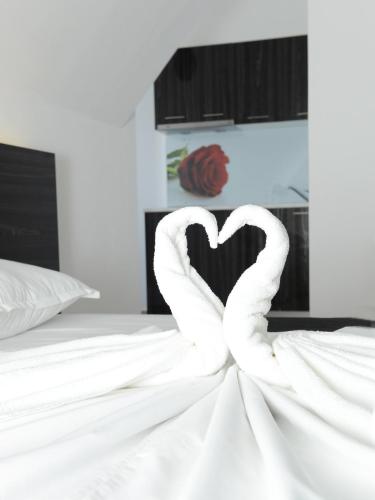 two white swans forming a heart on a bed at Diamond Kiten in Kiten