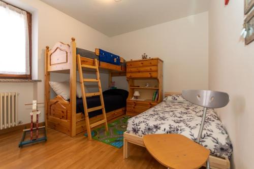 ein Schlafzimmer mit einem Etagenbett und einer Leiter in der Unterkunft Ciesa Migon in Alleghe