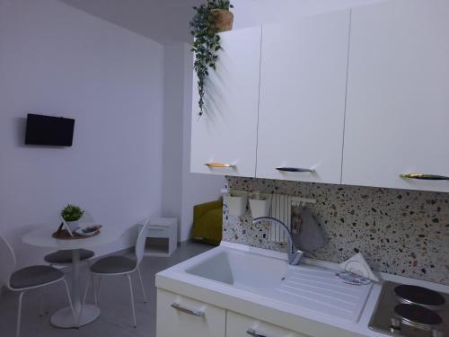 a kitchen with a sink and a table and chairs at Residence Le Isole in Marsala