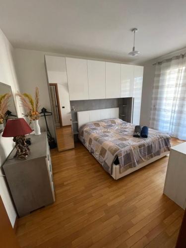 1 dormitorio con 1 cama y suelo de madera en Lussuoso Bilocale con parcheggio gratuito en Rovello Porro