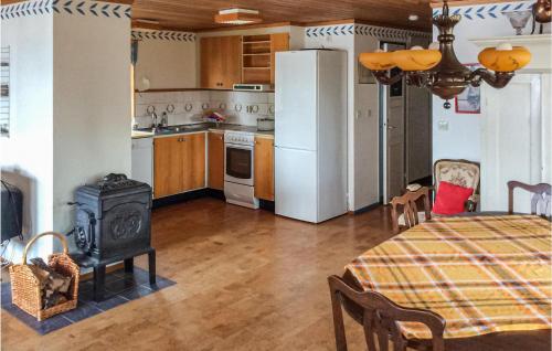 a kitchen with a table and a stove in a room at Beach Front Home In Ludvika With Sauna in Ludvika