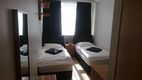 two beds in a small room with a window at 101 Guesthouse Hotel in Reykjavík