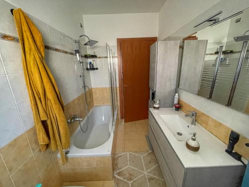 bagno con vasca, doccia e lavandino di Lussuoso Bilocale con parcheggio gratuito a Rovello Porro