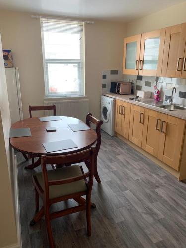 a kitchen with a table and chairs in a room at RUDGRAVE SQUARE WALLASEY in Wallasey