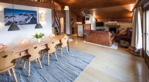 sala de estar con mesa de madera y sillas en Penthouse - Ski-in Ski-out 30 meters from Medran lift and 40 meters from W Hotel, en Verbier