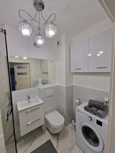 Baño blanco con aseo y lavamanos en 89 - Apartamenty Siedlce - Nowy apartament przy ul. Rakowieckiej, en Siedlce