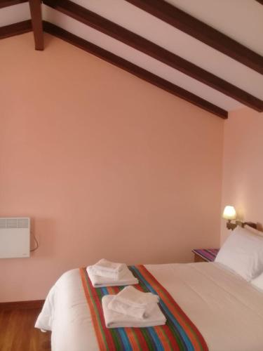 a bedroom with a bed with two towels on it at Quilla Wasi - ISLA DEL SOL in Comunidad Yumani