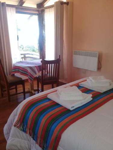 a bedroom with a bed with towels on it at Quilla Wasi - ISLA DEL SOL in Comunidad Yumani