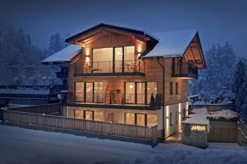 ein großes Haus mit einer Terrasse im Schnee in der Unterkunft AHRN Natur Apartment in Luttach