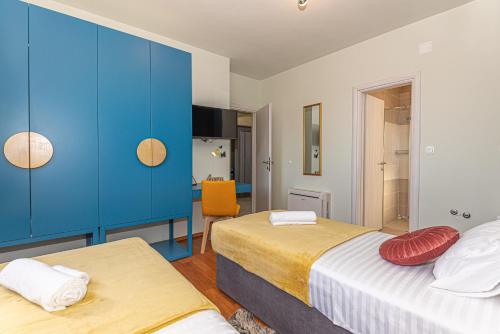a bedroom with two beds and blue cabinets at Villa Romansa Miljevci near Krka National Park in Širitovci