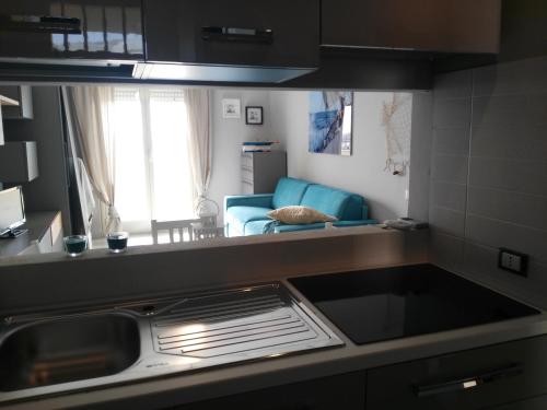 una cucina con lavello e un soggiorno di Azzurro mare Trapani a Trapani