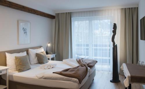 a bedroom with a bed and a large window at Gasthof Badl - Bed & Breakfast in Hall in Tirol