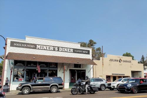 a man riding a motorcycle in front of a store at Julian House of Games in Julian