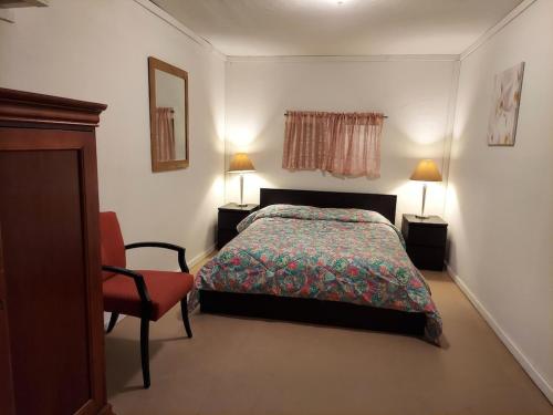a bedroom with a bed and a chair and two lamps at Julian House of Games in Julian