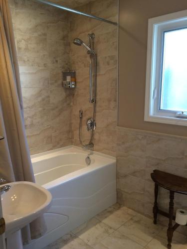 a bathroom with a tub and a sink at Cycle Inn Bed and Breakfast in Langford