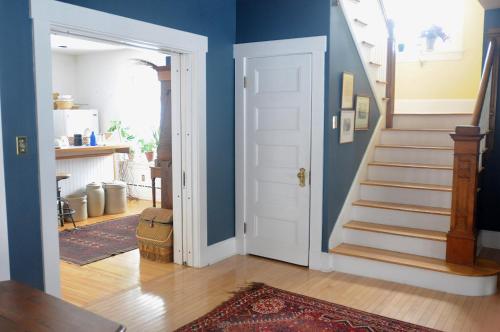 a hallway with blue walls and a white door at Napier House in Campbellton