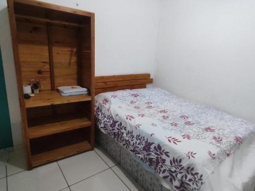 a small bedroom with a bed and a wooden cabinet at Hospedagens Icapui Mare Blu in Icapuí