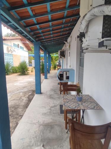 a patio with tables and chairs under awning at Hospedagens Icapui Mare Blu in Icapuí