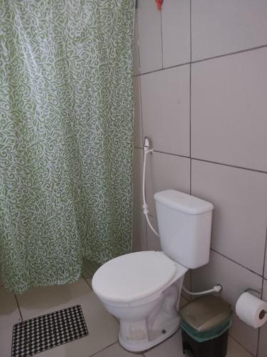 a bathroom with a toilet and a shower curtain at Hospedagens Icapui Mare Blu in Icapuí