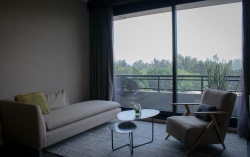 a living room with a couch and a table and a window at KOS Pilar Hotel in Pilar