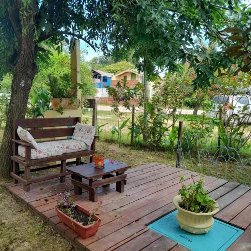 a wooden deck with a bench and a table at Complejo Sol de Valizas in Barra de Valizas