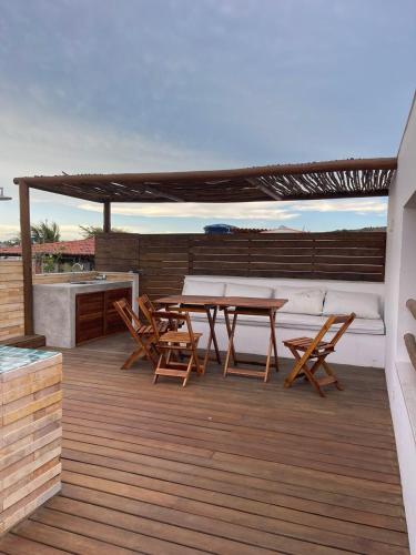 a patio with a table and chairs on a deck at Novo Apê Fabiano in Jericoacoara