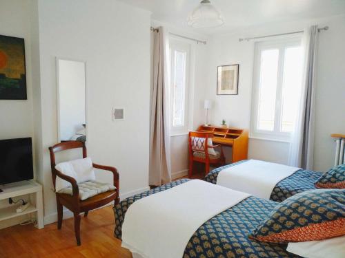 a hotel room with two beds and a television at La Maison de Thuy - Gîte en Auvergne in Gimeaux