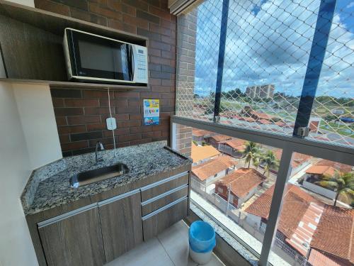 a kitchen with a sink and a large window at Piazza diRoma - Apartamentos JN in Caldas Novas