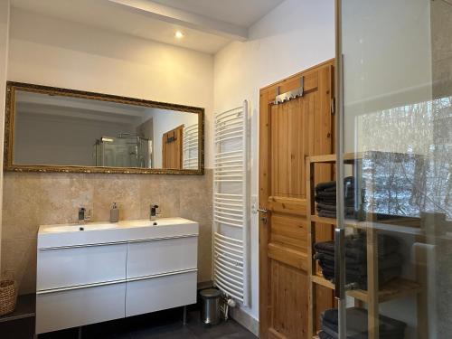 ein Badezimmer mit einem weißen Waschbecken und einem Spiegel in der Unterkunft Chalet Ferienhaus Dresden in Dresden