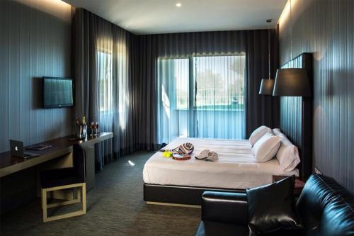 um quarto de hotel com uma cama, uma secretária e um sofá em Retamares Suites & Golf - a sólo 30 mn de Madrid - Vistas a los lagos y Montaña - Ven a descansar !! 