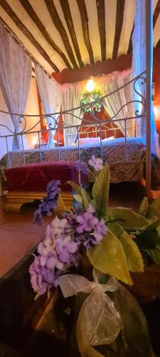a table with flowers in front of a bed at La Quinta rural in Valeria