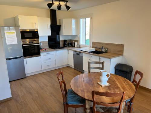 a kitchen with a wooden table and a table and chairs at Villa à Gap in Gap