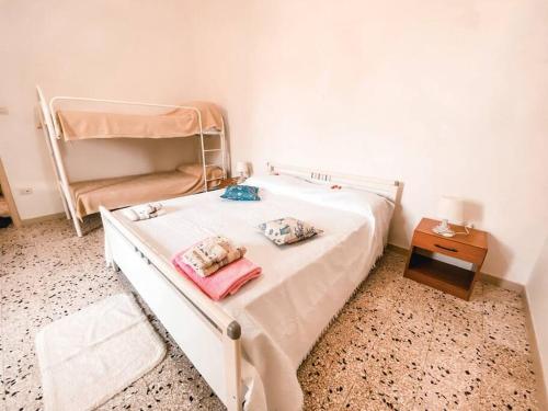 1 dormitorio con 1 cama blanca y 1 litera en Villetta tra ulivi e mare, en Torre Suda